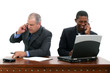 businessmen on cellphones at desk