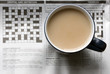 a cup of tea on a newspaper showing the crossword