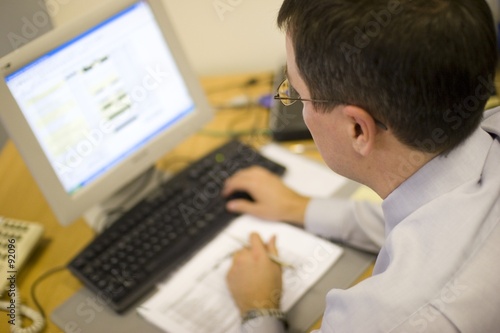 Photo: man using office computer man using office computer