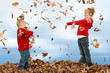 brother and sister throwing leaves
