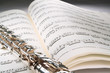 flute on an open musical score with gray background flute on an open musical score with gray background