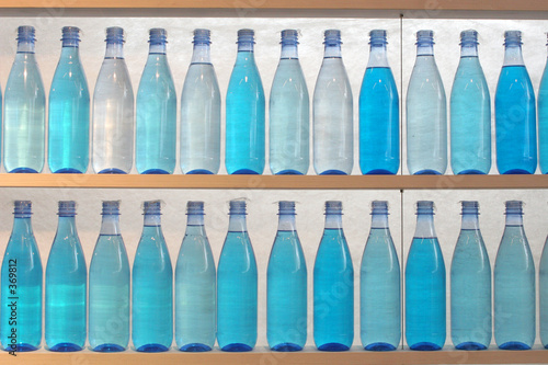 Photo: bottles filled with water, standing on the shelf bottles filled with water, standing on the shelf
