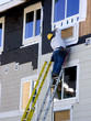 man hanging siding - construction