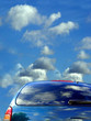 blue sky and clouds reflected in the car
