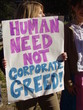 sign decries corporate greed at peace rally