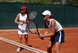 two fit, young, healthy women playing doubles at tennis in the s