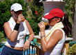 two young, fit, healthy, tanned women having a drink after a hot