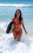 sexy attractive young woman in red bikini walking in from blue s