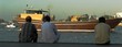 indian and pakistan workers watching boat in dubai