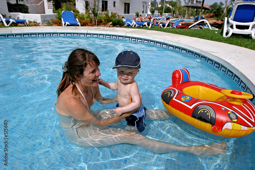Photo: young mother playing in children's swimming pool with toddler so young mother playing in children's swimming pool with toddler so