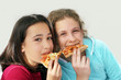 two girls eating pizza