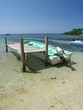 boat by pier at low tide at coast of roatan