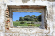 spanish countryside seen through hole in wall of ruins