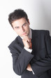 thinking business man in suit with hand on chin