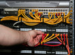 technician plugs a network cable into a patch pane