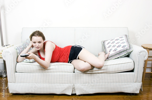 Photo: young woman with tv remote young woman with tv remote
