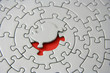 grey jigsaw with the missing piece laying above the red space