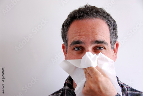 sick man blowing nose