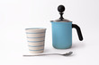 cup of cappuccino, long spoon and coffee kettle -