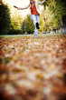 woman skipping in the leaves
