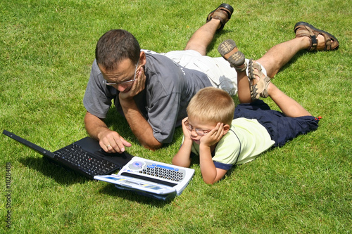 Photo: boy and his father's working on laptops boy and his father's working on laptops