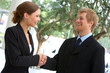 two businesspeople shaking hands.