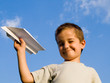 a smiling boy with a paper aeroplane toy
