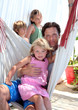 young father and children sitting in a hammock on vacation