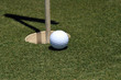 golf ball going in cup
