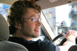young man driving in a city