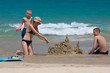happy family building sand castles on the beach