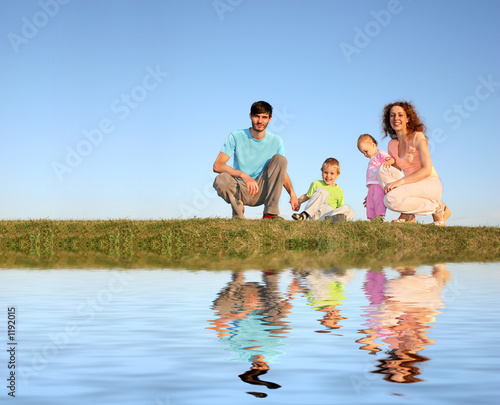 family of four on meadow and water family of four on meadow and water