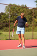 young man serving tennis ball