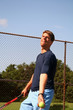 young man serving tennis ball