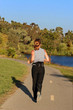 woman jogging along a river at sunset
