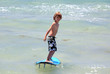 healthy young boy learning to surf