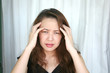 woman's both hand holding head with troubled expression