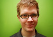 young man with glasses smiling