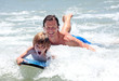 young father and son learning to surf young father and son learning to surf
