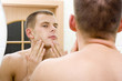 young man in the bathroom's mirror after shave
