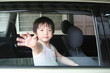 boy waving in the car
