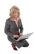 business woman kneeling working on laptop