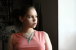 unhappy teen by the window
