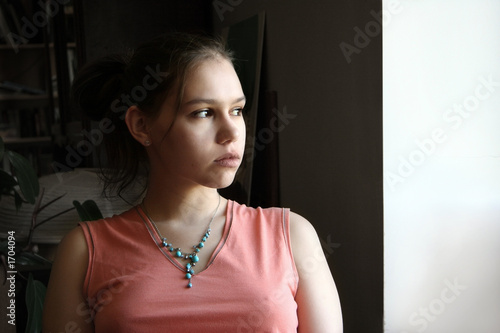 Photo: unhappy teen by the window unhappy teen by the window