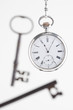 silver pocket watch and keys