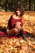 autumn girl sit on the yellow foliage.