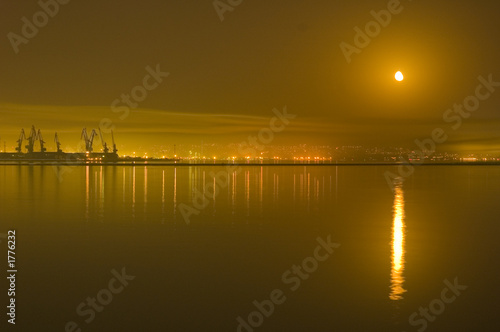 reflections of city and moon in the caspian sea -