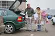 family put shop bags in car