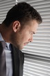  business man looking through window blinds