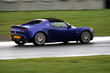 panning shot of a blue sports car on race circuit panning shot of a blue sports car on race circuit